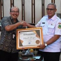 Bupati Kuningan saat menerima penghargaan Universal Health Coverage 2023.